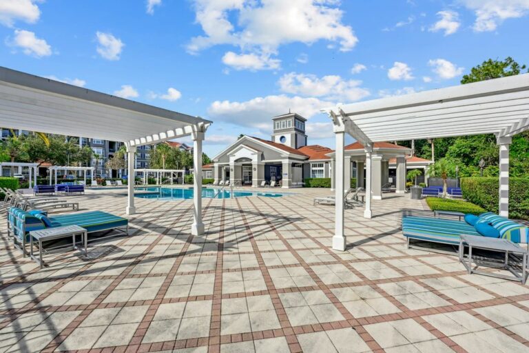 Inviting outdoor communal space with swimming pool, pergolas, and comfortable lounge seating, perfect for relaxation and social gatherings.