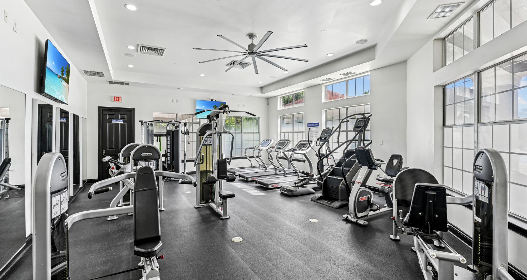 Modern fitness center with state-of-the-art equipment, sleek design, and ample natural light for an invigorating workout experience.