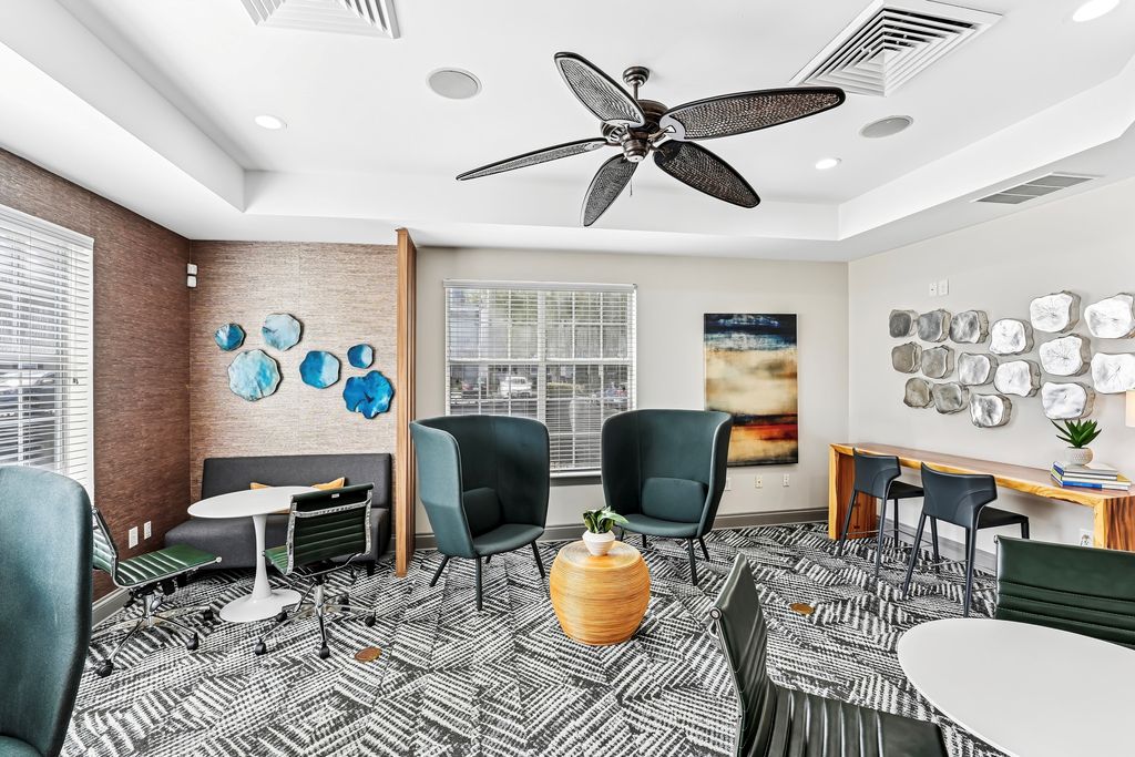 Clubhouse with contemporary decor, featuring stylish chairs, geometric patterns, and vibrant art, ideal for social gatherings.