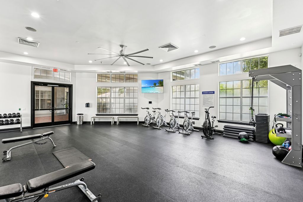 Modern fitness center with state-of-the-art equipment, bright windows, and sleek design, ideal for energetic workouts.