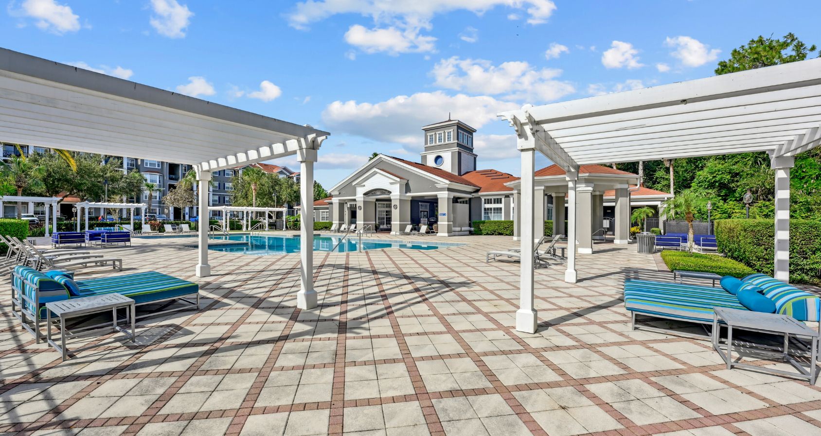 Inviting outdoor communal space with swimming pool, pergolas, and comfortable lounge seating, perfect for relaxation and social gatherings.